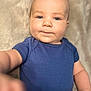 baby, blue_shirt, child, chubby_cheeks, close_up, curious, cute, expression, eyes, face, hand, indoor, infant, neutral_background, one_person, person, portrait, skin, soft_light, young_child