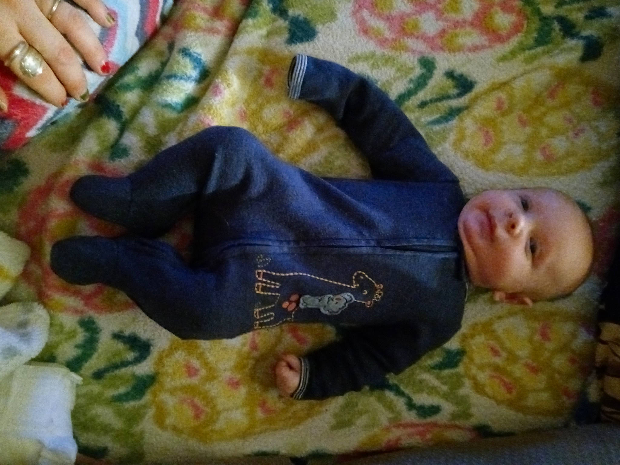 Axel is registered to the contest to win money with this photo: baby, baby_toddler_clothing, child, comfort, gesture, human_leg, linens, nail, outerwear, pattern, person, room, skin, sleeve, suit, textile, thumb, toddler, wood, woolen