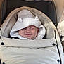baby, button, child, clothing, cozy, cute, ears, fabric, face, hood, infant, knitted, nap, outdoor, rest, smile, soft, stroller, warm, white