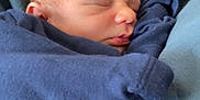 Ronnie-Lee is registered to the contest to win money with this photo: baby, blanket, blue_clothing, child, closeup, cozy, cradled, face, human, indoors, infant, newborn, newborn_baby, peaceful, person, portrait, resting, sleeping, soft_lighting, wrapped
