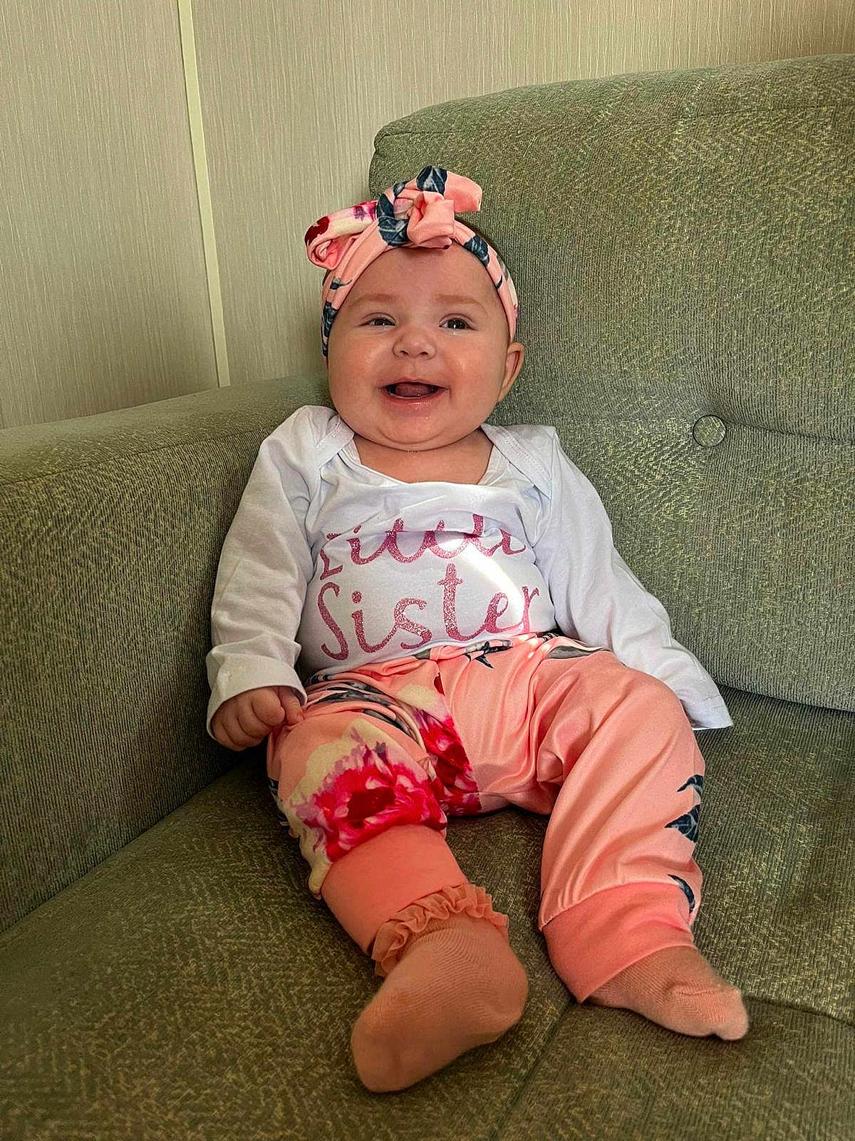 Bonnie joined the competition — help win amazing prizes! baby, child, smiling, sitting, couch, headband, pink, floral, clothing, happy, infant, portrait, indoor, cute, person, feet, sock, family, young, relaxed