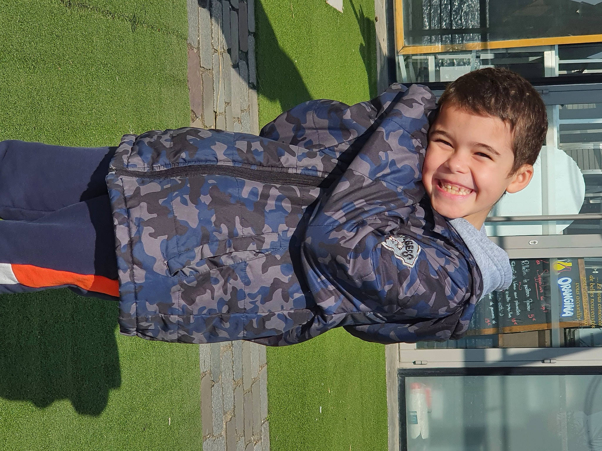 Léonid participe au concours pour gagner de l'argent avec cette photo : camouflage, child, fun, grass, happy, joy, leisure, military_camouflage, pattern, person, play, product, sitting, smile, t_shirt, toddler, tree