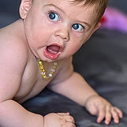 Nathaël a rejoint le concours — aidez-le/la à gagner de superbes lots ! baby, child, blue_eyes, curly_hair, bead_necklace, skin, expression, mouth_open, hand, mat, floor, indoors, portrait, cute, infant, candid, lying_down, closeup, person, young