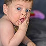 baby, child, blue_eyes, hand, mouth, skin, curious, lying_down, indoor, soft_surface, toy, blurred_background, portrait, infant, cute, young_child, skin_detail, expression, close_up, person
