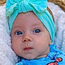 baby, infant, headband, bow, blue_clothing, butterfly_pattern, blanket, face, eyes, portrait, closeup, child, soft_texture, outdoor, natural_light, cute, young_child, baby_girl, headwear, colorful