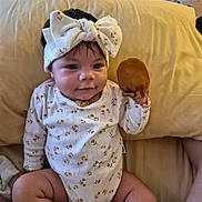 Ila Eternity joined the competition — help win amazing prizes! baby, child, infant, bow, headband, onesie, floral_clothing, toy, plush_toy, sitting, couch, cushion, indoor, home, portrait, smiling, face, dark_hair, cozy, photography