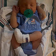 Marvin is registered to the contest to win money with this photo: newborn, baby, pacifier, sleeping, hospital, blanket, onesie, blue_clothing, infant, bed, socks, wrapped, cute, small, child, person, resting, indoors, hospital_band, peaceful