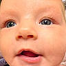 baby, infant, child, face, portrait, close_up, wide_eyes, blue_eyes, open_mouth, curious, indoors, blanket, soft_lighting, caucasian, head, nose, lips, eyes, baby_portrait, photography