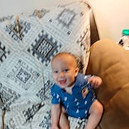 Zander is registered to the contest to win money with this photo: baby, blur, couch, blanket, pattern, smile, happy, child, indoor, furniture, blue_clothing, sitting, infant, cute, small, foot, hand, head, skin, room