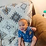 baby, blur, couch, blanket, pattern, smile, happy, child, indoor, furniture, blue_clothing, sitting, infant, cute, small, foot, hand, head, skin, room