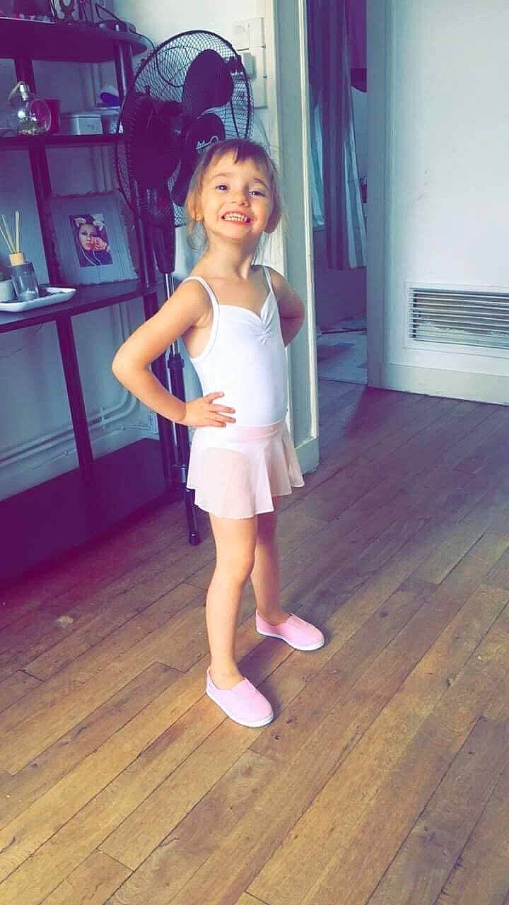 Lana participe au concours pour gagner de l'argent avec cette photo : floor, flooring, hardwood, human_leg, joy, knee, laminate_flooring, person, pink, shelf, shorts, shoulder, smile, sock, sportswear, standing, thigh, toddler, trunk, waist