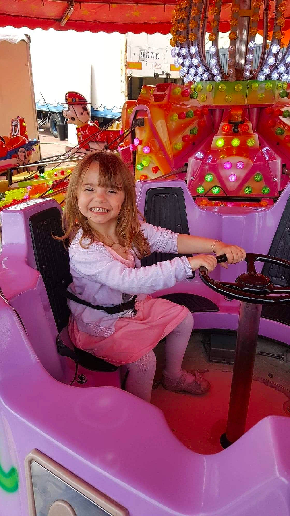 Lana participe au concours pour gagner de l'argent avec cette photo : automotive_design, automotive_exterior, bumper, chair, event, fashion, fun, happy, joy, leisure, magenta, motor_vehicle, person, pink, recreation, red, smile, snapshot, steering_wheel, thigh