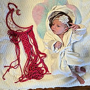 Jasmine joined the competition — help win amazing prizes! newborn, baby, infant, child, portrait, lying_down, robe, headband, flower, pastel, blanket, fuzzy_blanket, yarn, macrame, moon, handmade_decoration, wooden_floor, indoor, sleeping, date_stamp