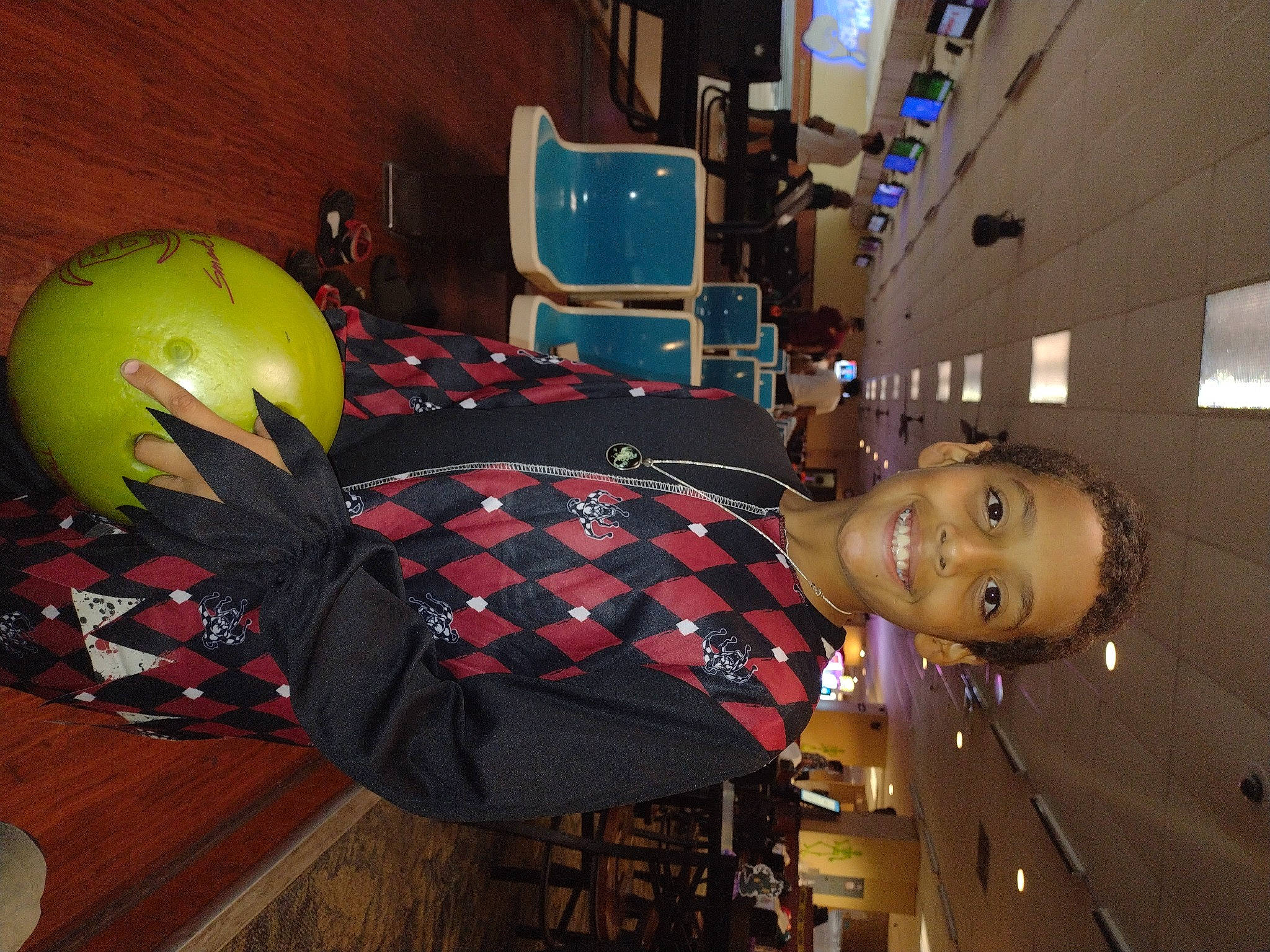 Brett is registered to the contest to win money with this photo: balloon, carmine, ceiling, chair, cool, engineering, fashion_accessory, flooring, fun, helmet, human_leg, joy, machine, motorcycle_helmet, pattern, person, personal_protective_equipment, plaid, room, smile