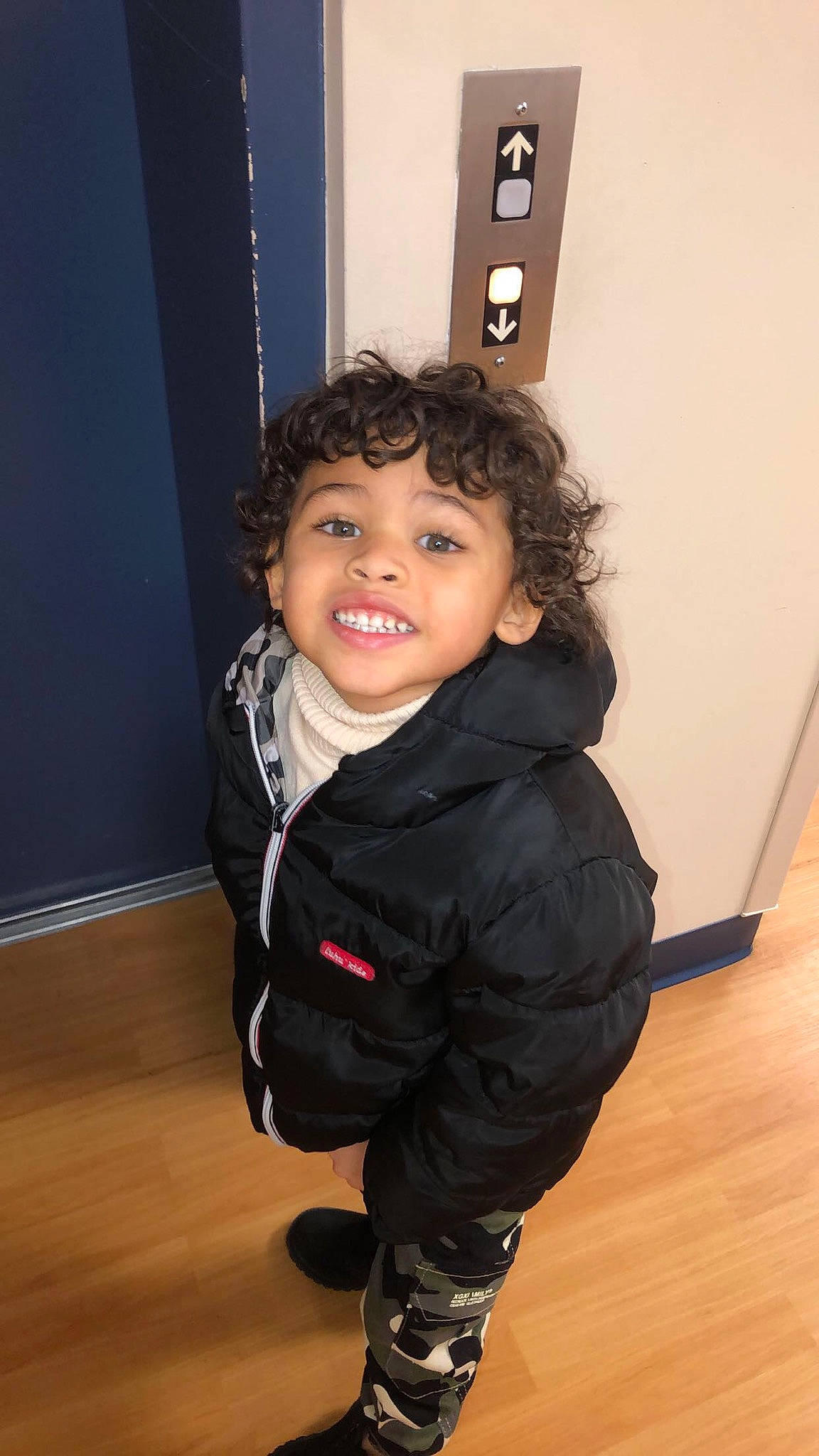 Kyaire is registered to the contest to win money with this photo: baby_toddler_clothing, cheek, child, comfort, electric_blue, floor, flooring, happy, hardwood, jacket, joy, laminate_flooring, leg, person, sitting, sleeve, smile, toddler, varnish, wood