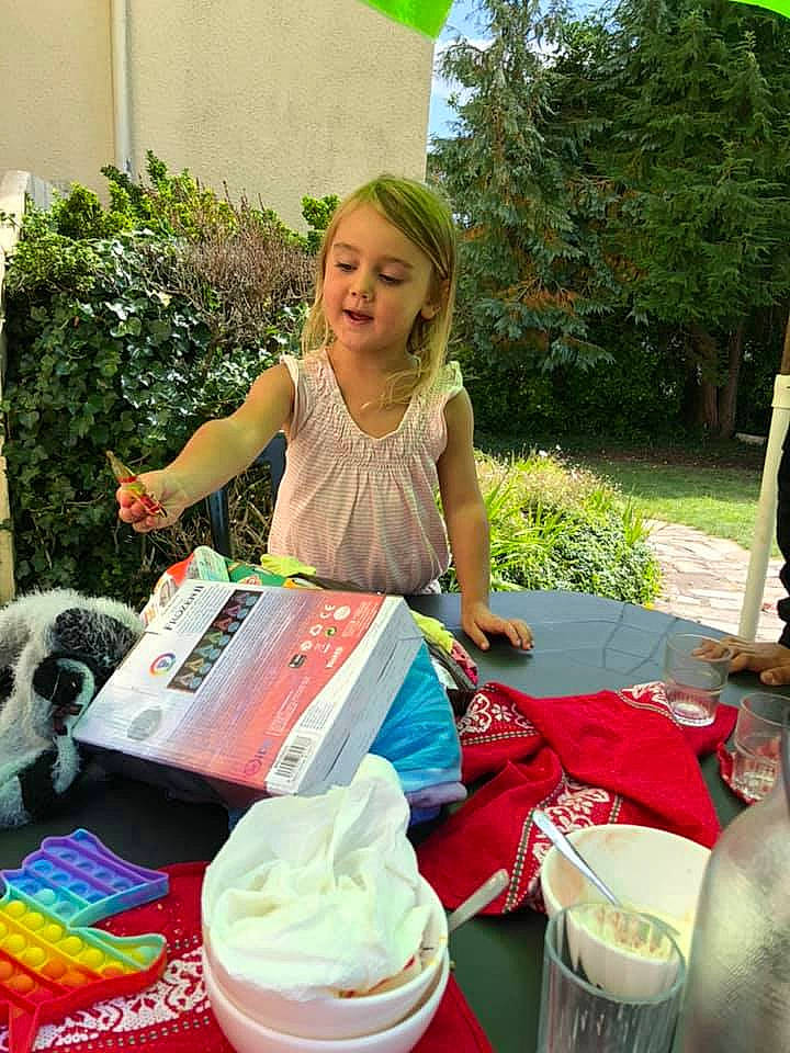 Jessica participe au concours pour gagner de l'argent avec cette photo : bag, basket, chair, comfort_food, drink, event, grass, green, handbag, happy, leisure, luggage_and_bags, person, pink, plant, recreation, smile, t_shirt, table, toddler