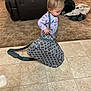 Raelynn joined the competition — help win amazing prizes! toddler, child, pajamas, bag, floor, carpet, living_room, toy, couch, blanket, tile_floor, person, indoor, curious, small_bag, patterned_bag, baby, young_child, furniture, home