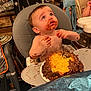 Randall is registered to the contest to win money with this photo: baby, high_chair, cake, chocolate, messy, food, kitchen, child, birthday, frosting, plate, person, indoor, table, hands, face, eyes, hair, expression, seat