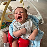 Vinnie-Jay is registered to the contest to win money with this photo: baby, infant, smiling, laughing, red_seat, blue_blanket, white_socks, baby_bib, carpet, baby_toys, play_gym, living_room, soft_toys, cute, child, happy, indoor, person, young_child, cozy
