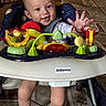 baby, child, walker, toy, smile, indoor, floor, socks, face, person, play, seat, happy, cute, legs, hand, furniture, colorful, expression, home