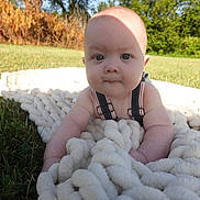 Beckham joined the competition — help win amazing prizes! baby, infant, blanket, outdoor, grass, sunlight, shadow, closeup, face, blue_eyes, cute, child, nature, summer, greenery, person, skin, sleeveless, baby_clothes, toddler