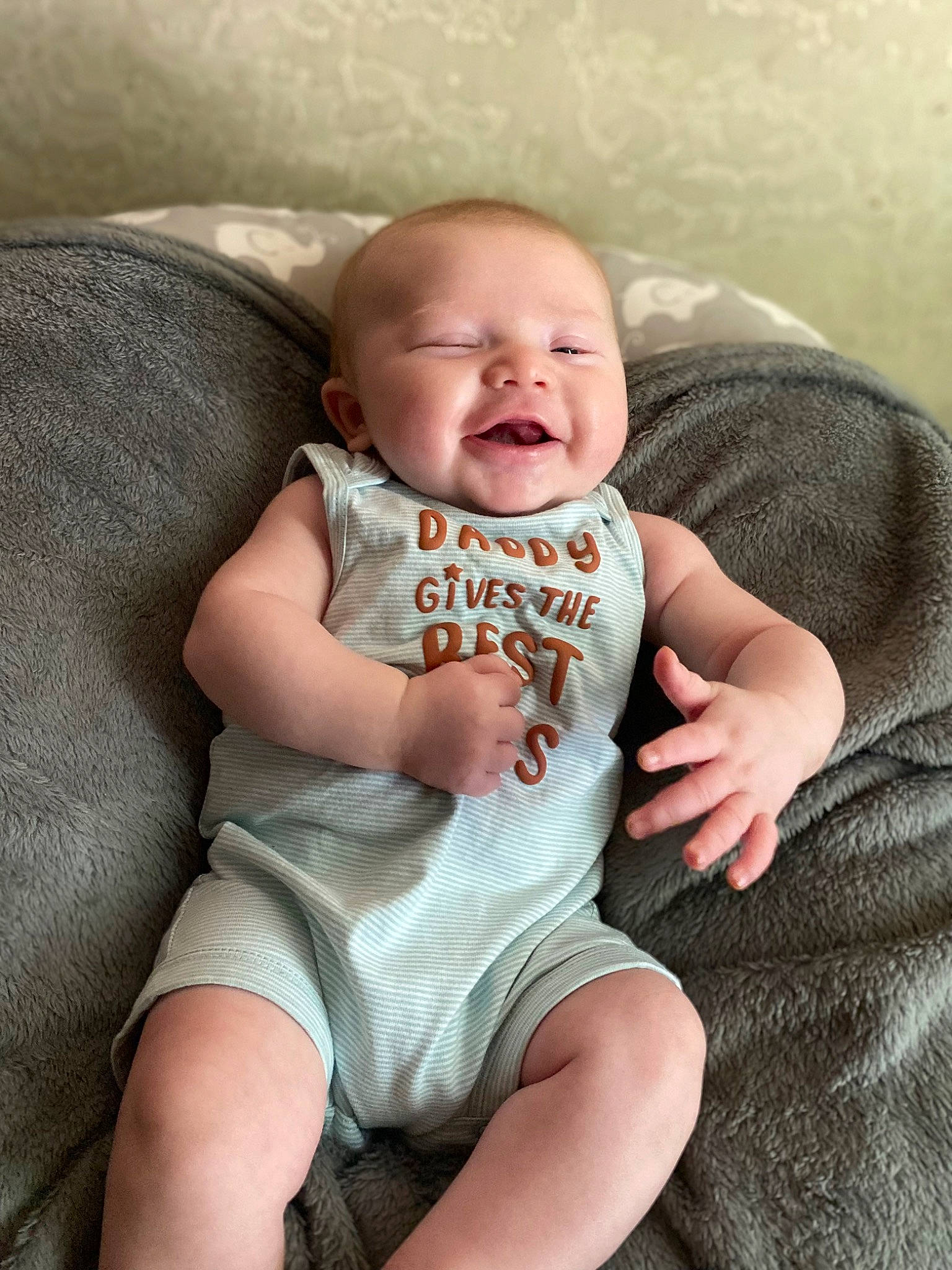 Josiah is registered to the contest to win money with this photo: baby, baby_toddler_clothing, cheek, child, comfort, finger, flash_photography, grey, happy, human_leg, knee, lip, person, sitting, skin, sleeve, smile, stomach, t_shirt, thigh