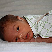 Azael is registered to the contest to win money with this photo: baby, infant, child, sleeping, lying_down, blanket, soft_texture, green_clothing, white_clothing, face, head, curious, newborn, resting, indoors, portrait, cute, peaceful, closeup, skin