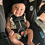 baby, car_seat, child, infant, headband, smile, blue_eyes, straps, black_clothing, cute, skin, foot, hand, portrait, sitting, indoor, safety, seat_belt, clothing, person