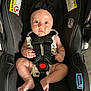 baby, infant, car_seat, black_headband, blue_eyes, buckle, safety_harness, legs, feet, clothing, indoor, person, child, cute, seat, protective_gear, warning_label, fabric, closeup, skin