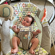 Aleena joined the competition — help win amazing prizes! baby, infant, baby_rocker, plush_toys, patterned_fabric, carpet, indoor, child, cute, comfort, soft_toys, colorful, playful, relaxing, person, small_child, seated, looking, home, furniture
