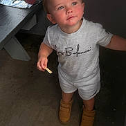 Kohen joined the competition — help win amazing prizes! boots, boy, bright_eyes, casual_wear, child, concrete_floor, curious_expression, grey_clothing, indoor, light, person, portrait, rosy_cheeks, shadow, short_hair, snack, standing, table, toddler, young_child