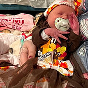 Harper is registered to the contest to win money with this photo: newborn, baby, infant, pacifier, headband, bow, thanksgiving, clothing, hospital, bed, blanket, person, sleeping, cute, tutu, hand, holding, toddler, celebration, holiday