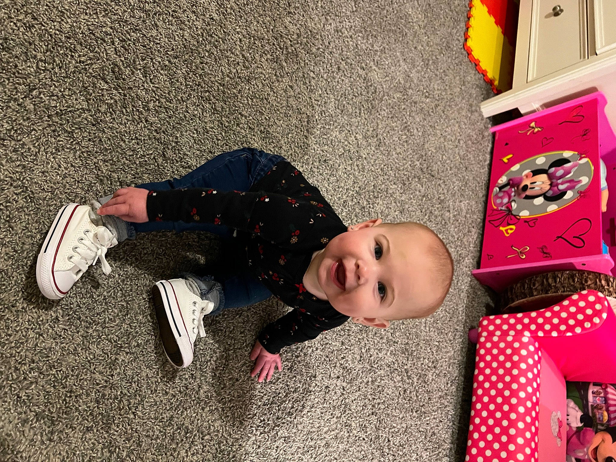 Oaklynn is registered to the contest to win money with this photo: baby, baby_toddler_clothing, child, floor, flooring, foot, fun, human_leg, knee, magenta, pattern, person, play, room, shelf, sitting, smile, textile, toddler, toy