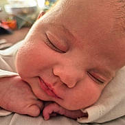 Sophia is registered to the contest to win money with this photo: baby, sleeping, close_up, face, hand, infant, cheeks, soft, white_clothing, peaceful, newborn, skin, portrait, indoors, cute, relaxed, young_child, rest, child, cozy