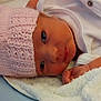 Sophia joined the competition — help win amazing prizes! newborn, baby, infant, pink_hat, knitted_hat, white_towel, soft_texture, blue_background, lying_down, face, eyes, hand, skin, cute, cozy, newborn_clothing, baby_gaze, portrait, indoors, resting