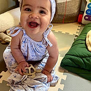 Gwen joined the competition — help win amazing prizes! baby, child, smiling, headband, bow, toy, turtle, play_mat, indoor, happy, sitting, clothing, dress, hand, face, infant, cute, colorful, floor, home