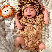 Evans Ferrer joined the competition — help win amazing prizes! baby, sleeping, knitted_clothing, lion_costume, plush_toy, balloons, blanket, infant, cute, cozy, soft_toys, child, newborn, resting, warm, portrait, headwear, sock, peaceful, indoors