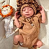 baby, sleeping, knitted_clothing, lion_costume, plush_toy, balloons, blanket, infant, cute, cozy, soft_toys, child, newborn, resting, warm, portrait, headwear, sock, peaceful, indoors