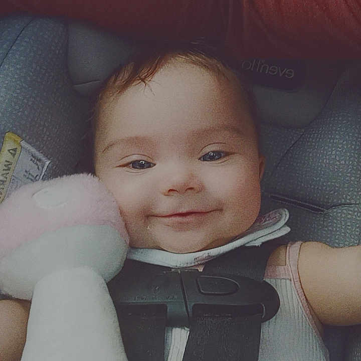 Emma is registered to the contest to win money with this photo: accessories, baby, belt, bodypart, car, car_interior, carseat, couch, cushion, face, finger, furniture, hand, head, homedecor, person, photography, portrait, transportation, vehicle