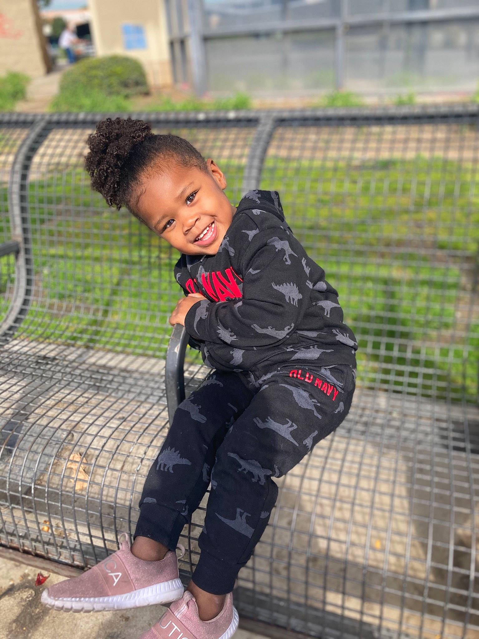 Alaska is registered to the contest to win money with this photo: child, facial_expression, fence, fun, grass, happy, joy, leg, leisure, people_in_nature, person, plant, recreation, shoe, skin, sleeve, smile, sneakers, street_fashion, thigh