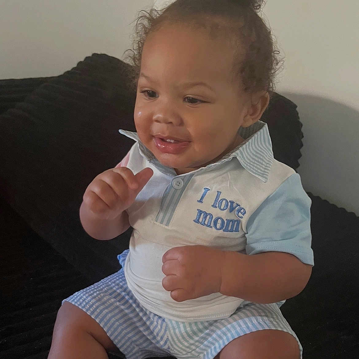 Louie is registered to the contest to win money with this photo: baby, toddler, child, curly_hair, smiling, sitting, indoor, clothing, shirt, shorts, love_mom, furniture, couch, happy, person, portrait, cute, young_child, skin, hair_bun