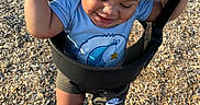 Louie joined the competition — help win amazing prizes! child, toddler, swing, playground, outdoor, happy, smiling, curly_hair, blue_shirt, shorts, socks, nike_logo, woodchips, sunlight, holding, play, fun, baby, person, summer