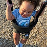 child, toddler, swing, playground, outdoor, happy, smiling, curly_hair, blue_shirt, shorts, socks, nike_logo, woodchips, sunlight, holding, play, fun, baby, person, summer