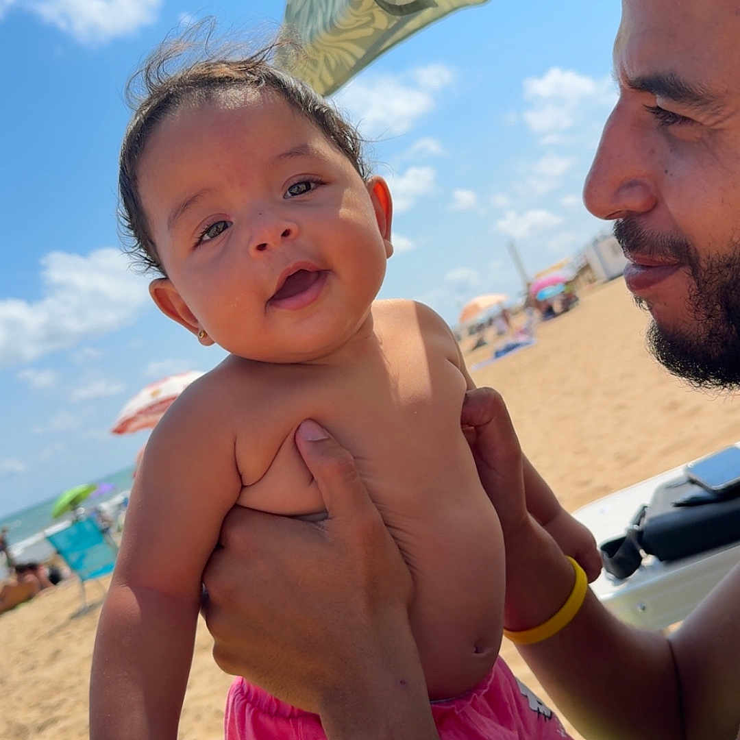 Mayar participe au concours pour gagner de l'argent avec cette photo : baby, beach, child, family, happy, holding, man, ocean, outdoor, person, portrait, relaxation, sand, shorts, sky, smile, summer, sunny, umbrella, vacation
