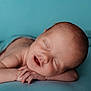 newborn, baby, sleeping, peaceful, closeup, portrait, infant, skin, hands, face, resting, blue_background, serene, smile, child, cute, young, soft, calm, lying_down