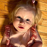 Clara joined the competition — help win amazing prizes! baby, blonde_hair, casual, child, cute, eyes, face, frills, hair, indoor, innocence, looking_up, person, pigtails, pink_clothing, portrait, skin, toddler, wooden_floor, young_child