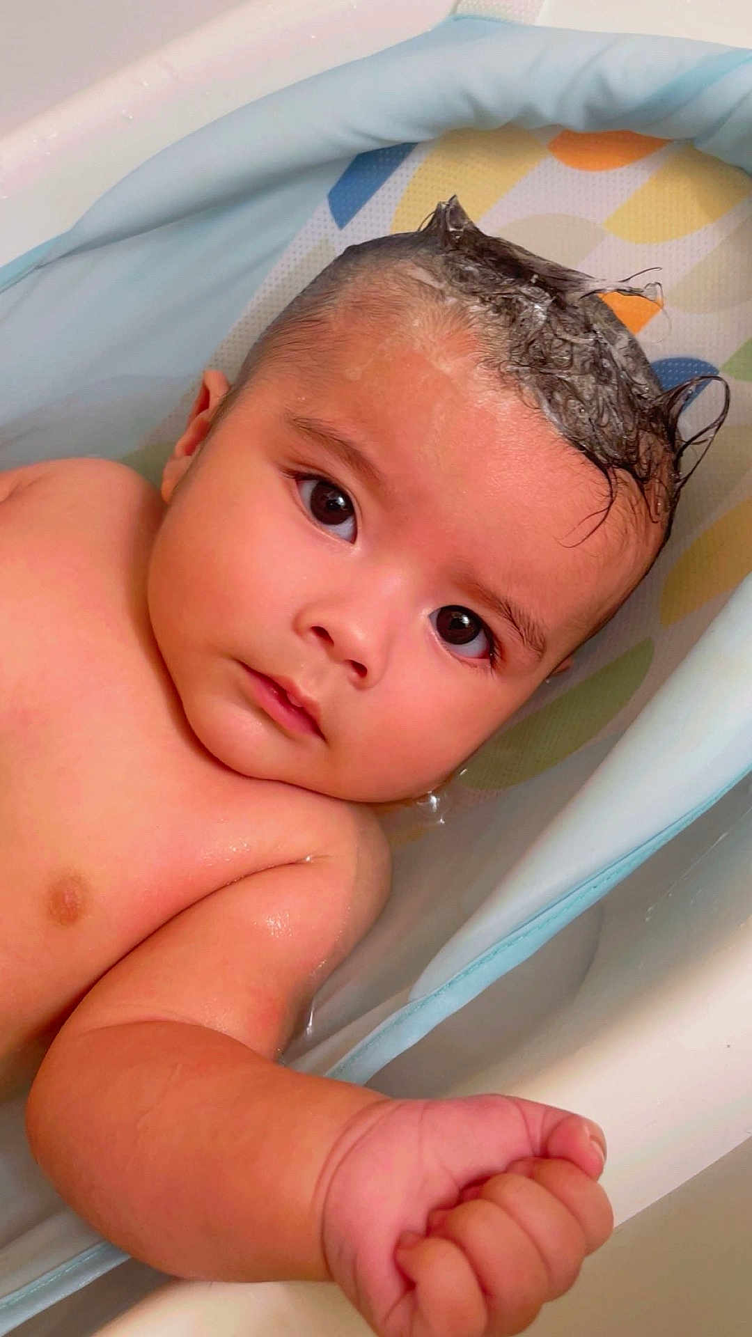 Santos is registered to the contest to win money with this photo: baby, child, bathtub, water, foam, shampoo, mohawk, skin, arm, hand, face, eyes, expression, cute, infant, bath, bathroom, wet, relaxed, portrait