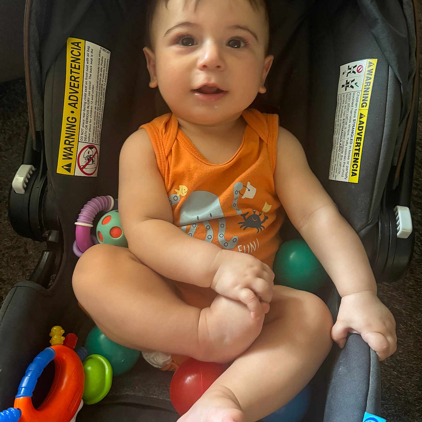 Soufain joined the competition — help win amazing prizes! baby, ball, casual, child, curious, cute, face, foot, hand, indoor, infant, orange_clothing, playtime, portrait, seat, smile, stroller, toy, warning_label, young_child