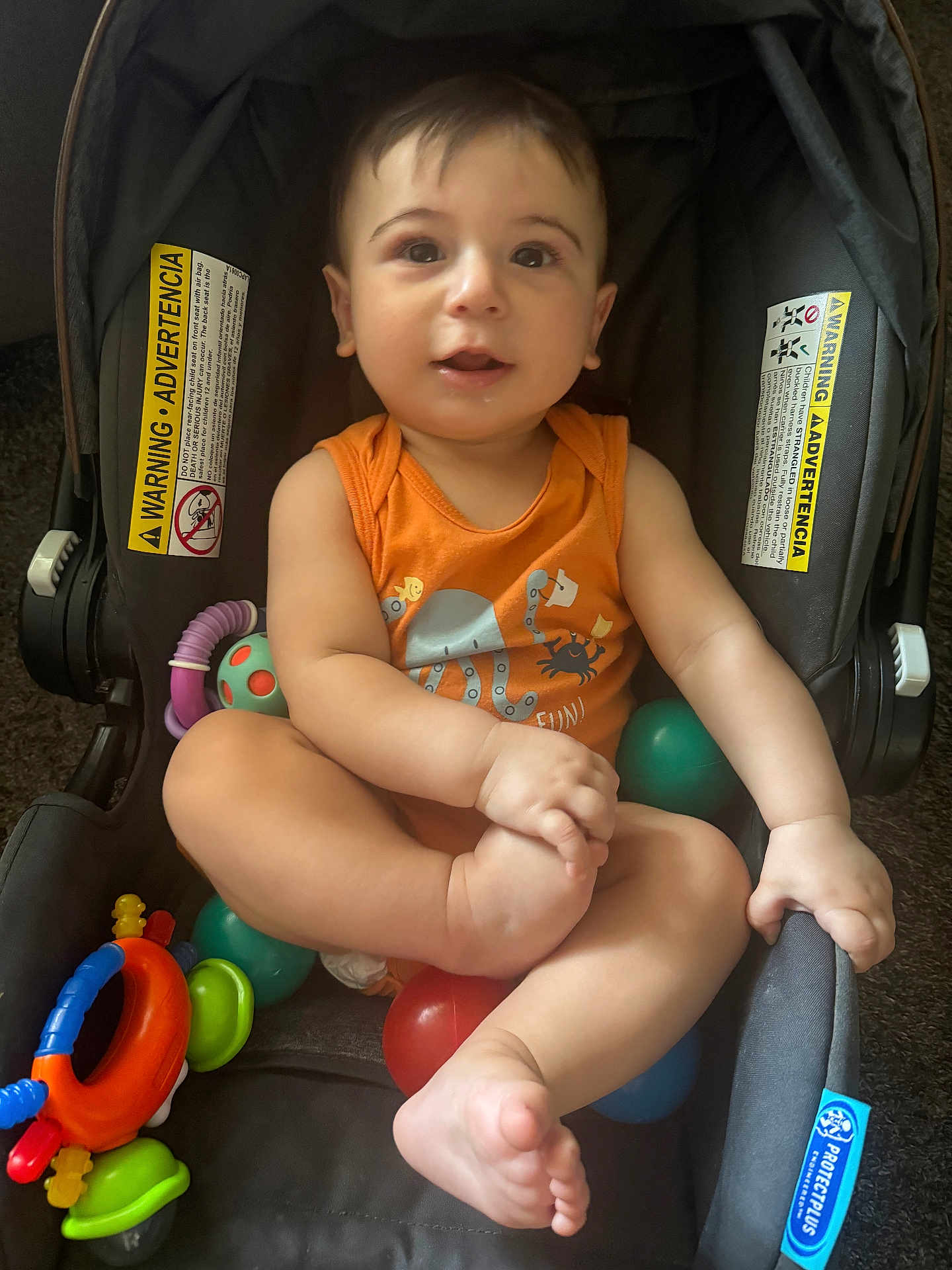 Soufain joined the competition — help win amazing prizes! baby, ball, casual, child, curious, cute, face, foot, hand, indoor, infant, orange_clothing, playtime, portrait, seat, smile, stroller, toy, warning_label, young_child