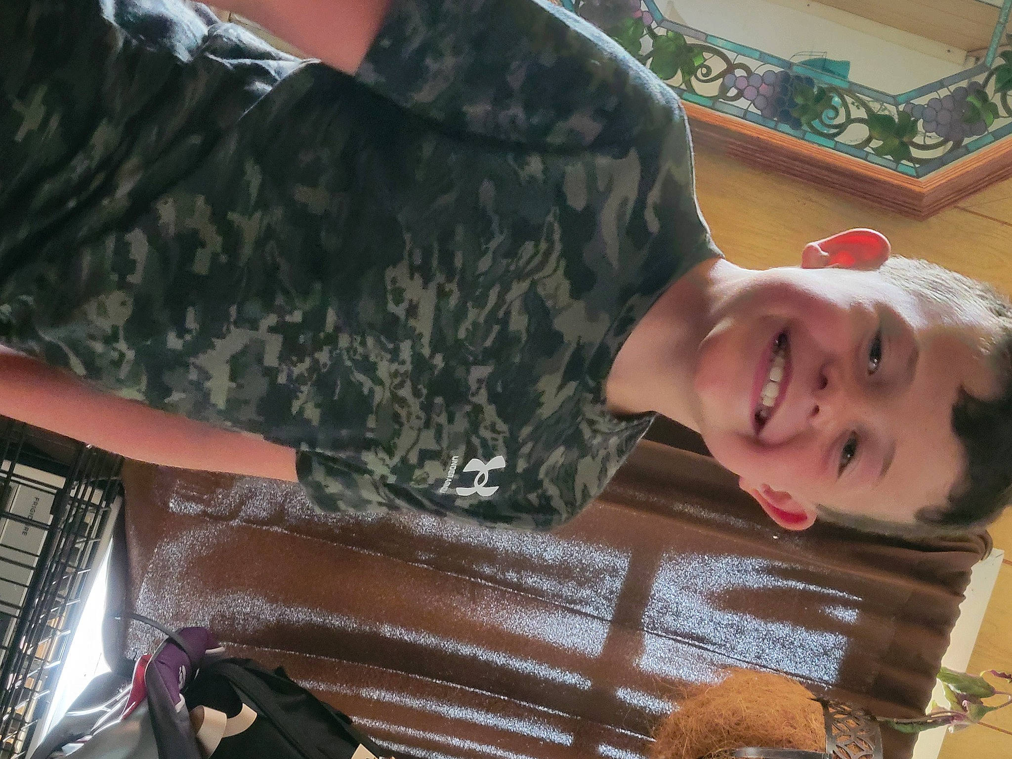 Jaxsyn is registered to the contest to win money with this photo: camouflage, child, eyewear, fun, happy, joy, military_camouflage, military_person, military_uniform, organ, pattern, person, sitting, sleeve, smile, t_shirt, toddler, wood